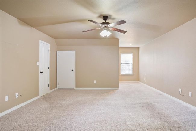 Carpeted empty room with baseboards, a textured ceiling, and a ceiling fan | Image 31