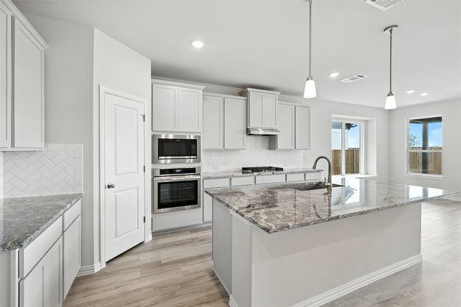 Kitchen with stainless steel appliances, light wood finished floors, decorative backsplash, recessed lighting, and under cabinet range hood | Image 7