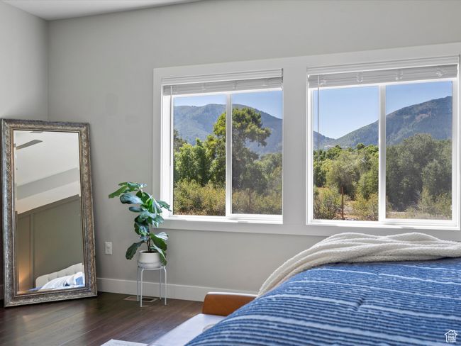 Bedroom with a mountain view, dark wood-style flooring, and baseboards | Image 36