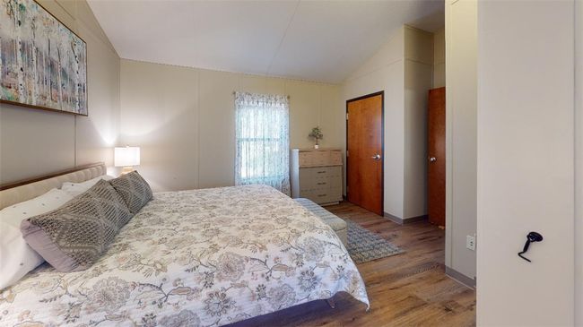 Bedroom featuring vaulted ceiling, wood finished floors, and baseboards | Image 37