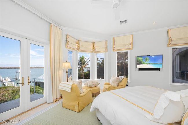 Primary bedroom has french doors out to balcony area; serene sitting area with natural light | Image 27