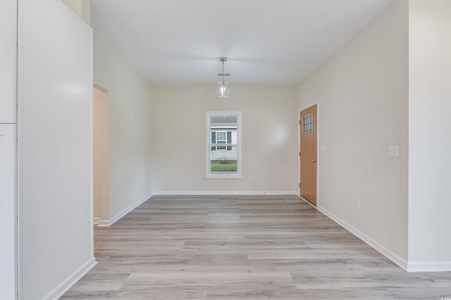 Unfurnished dining area with light wood-style flooring and baseboards | Image 7
