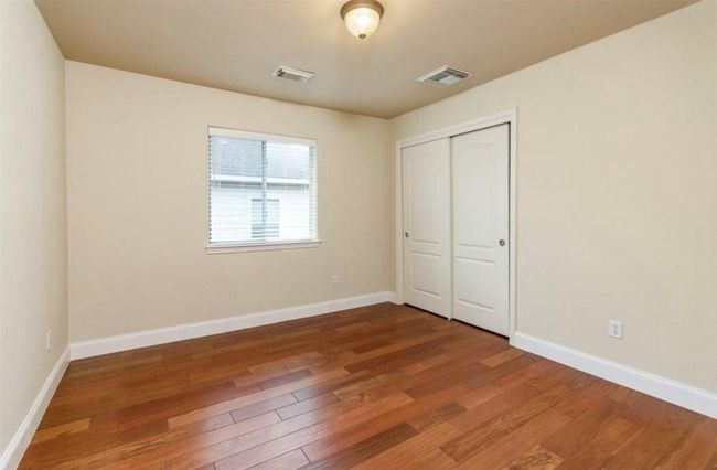 Unfurnished bedroom featuring wood finished floors, baseboards, and a closet | Image 23