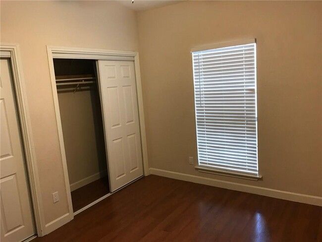 Unfurnished bedroom featuring baseboards and dark wood-type flooring | Image 6
