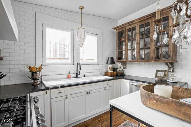 kitchen featuring a healthy amount of sunlight, stainless steel appliances, custom range hood and upper cabinets | Image 16