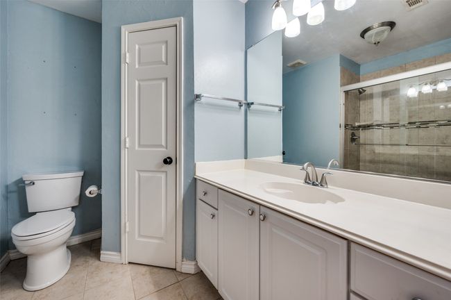 Full bath with a shower stall, tile patterned floors, toilet, vanity, and baseboards | Image 24