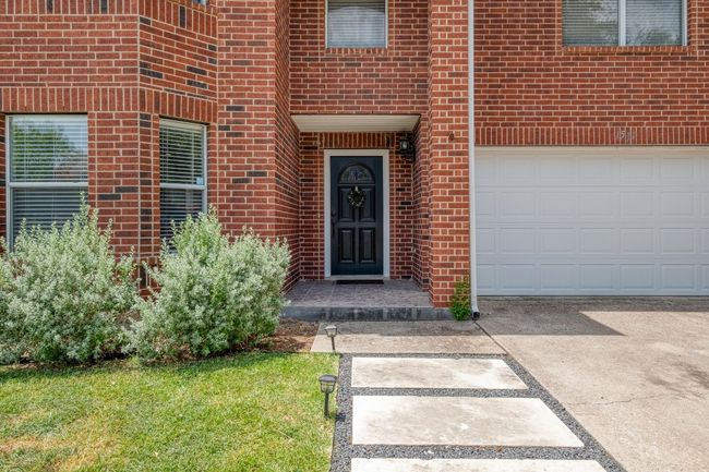 Doorway to property with brick siding, driveway, and an attached garage | Image 37