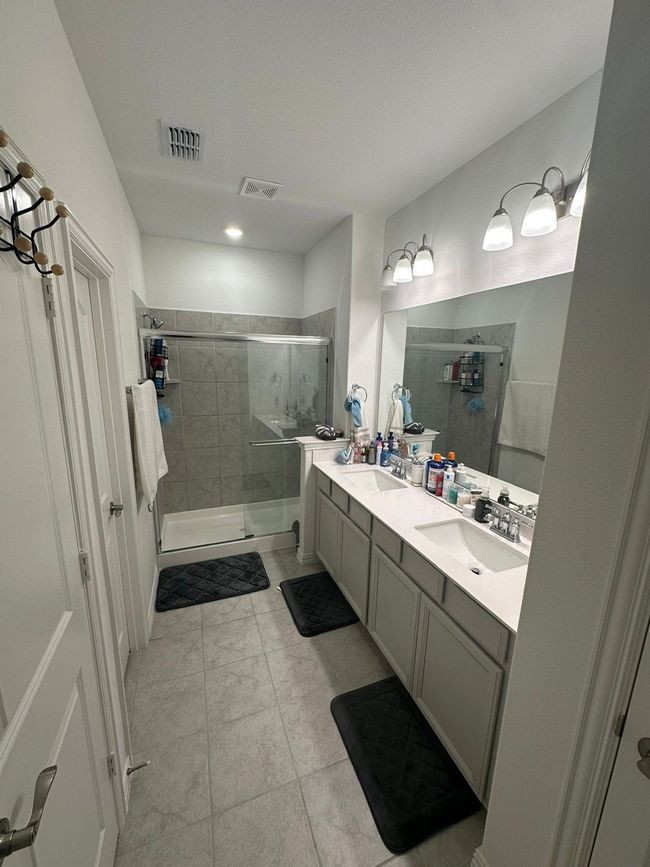 Full bath featuring a stall shower, double vanity, and tile patterned floors | Image 10