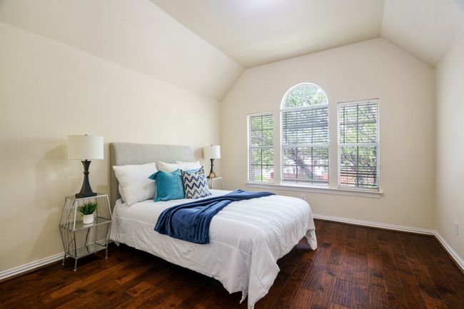 Bedroom with baseboards, vaulted ceiling, and wood flooring | Image 16