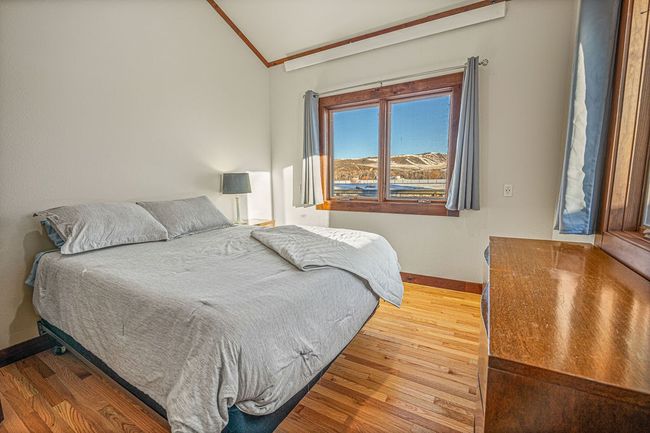 Bedroom with baseboards, vaulted ceiling, wood finished floors, and ornamental molding | Image 19