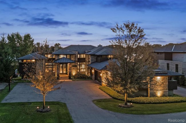 View of front of house with curved driveway, stone siding, a standing seam roof, a chimney, and a balcony | Image 39