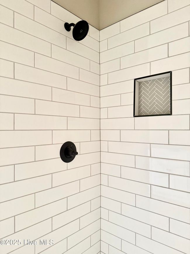 gorgeous large tiled primary shower with Black Faucets and built in niche' for shampoo and conditioner storage. | Image 34