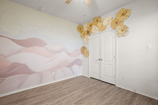 Empty room with a ceiling fan, baseboards, and wood finished floors | Image 6