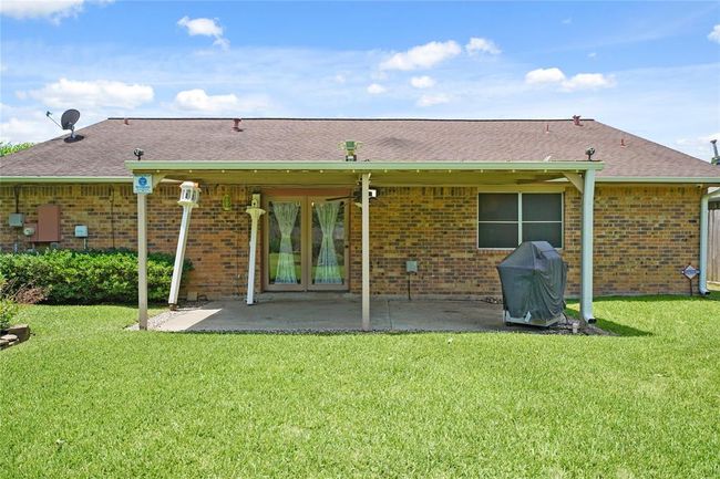 Pictured is the backyard with a covered patio, perfect for outdoor relaxation or entertaining. It features a well-maintained lawn, providing a cozy and functional outdoor space. | Image 28