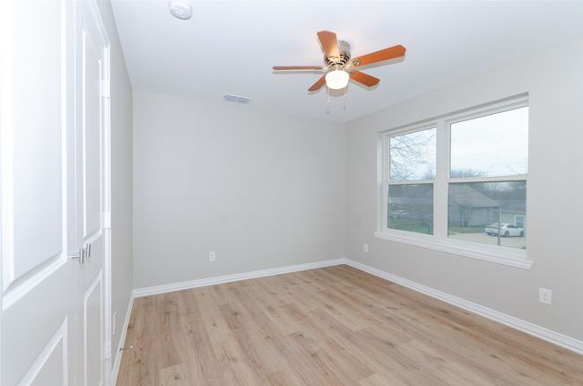 Spare room featuring ceiling fan, light wood-style floors, visible vents, and baseboards | Image 19