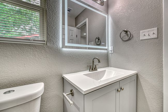 Bathroom featuring vanity and a textured wall | Image 22