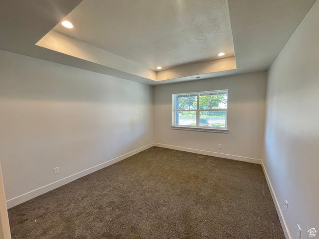 Empty room featuring dark colored carpet, recessed lighting, a raised ceiling, and baseboards | Image 14