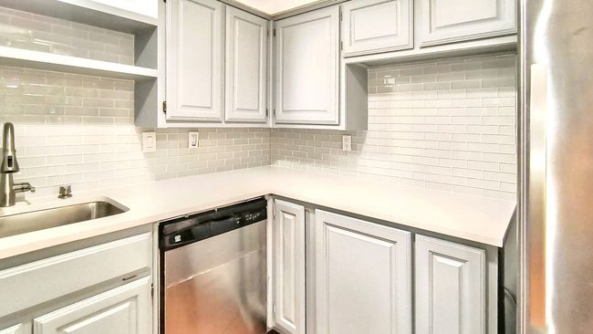 Kitchen featuring white cabinets, dishwasher, sink, and backsplash | Image 12