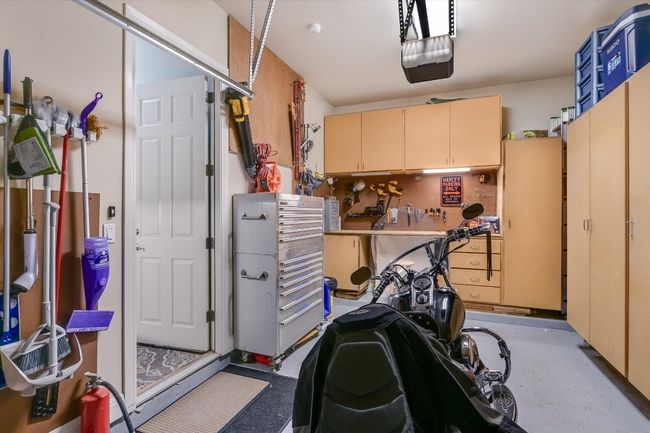 Garage with a garage door opener, and workshop. | Image 38