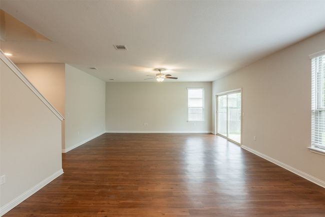 Spare room with plenty of natural light, a ceiling fan, dark wood finished floors, and visible vents | Image 9