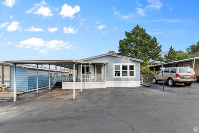 Manufactured / mobile home featuring covered porch and a carport | Image 1