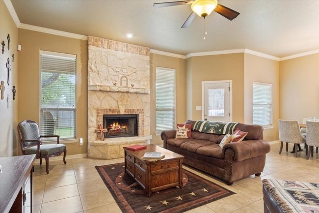 Living area featuring light tile patterned floors and ornamental molding | Image 11