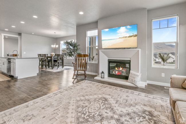Living area featuring wood-type flooring, a glass covered fireplace, baseboards, and recessed lighting | Image 10