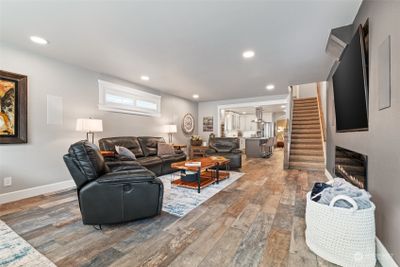 Living room with huge electric fireplace and 85" TV with surround sound. Open to kitchen. | Image 2