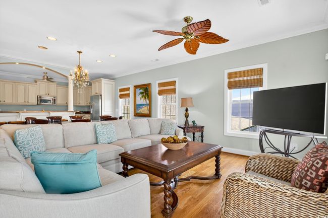 Living room featuring crown molding, a ceiling fan, light wood-style flooring, a chandelier, and recessed lighting | Image 5