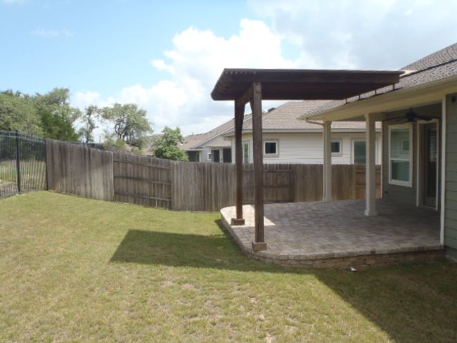 Fenced backyard featuring a patio area and a ceiling fan | Image 11