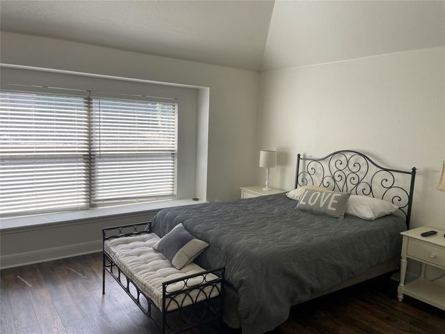Bedroom featuring vaulted ceiling, wood finished floors, and baseboards | Image 16