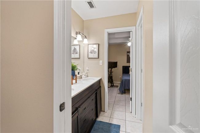 Bathroom with double vanity, tile patterned flooring, ensuite bathroom, and a ceiling fan | Image 8