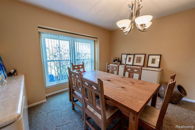 Dining area featuring carpet flooring and a chandelier | Image 15