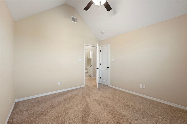 Empty room with a ceiling fan, light colored carpet, and high vaulted ceiling | Image 22