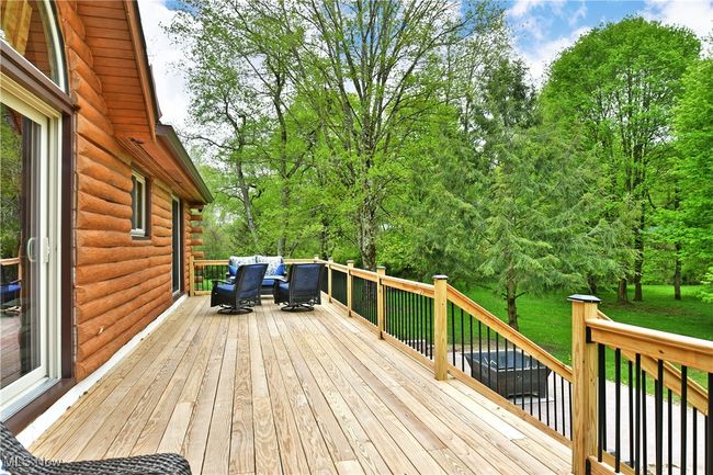 Wooden deck featuring an outdoor hangout area | Image 48