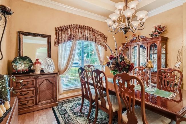 Dining room with an inviting chandelier, light wood-style flooring, and crown molding | Image 9