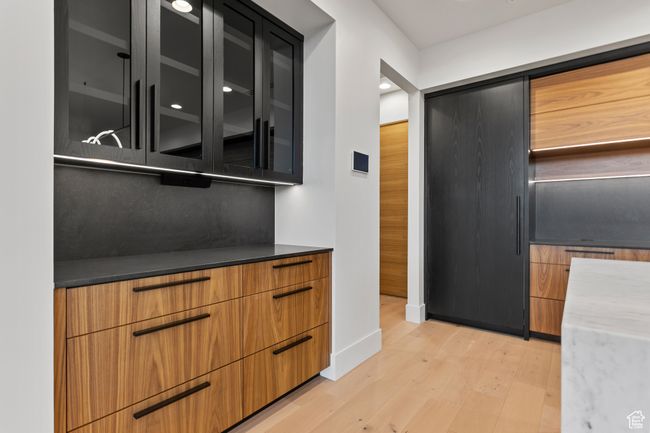 Bar with baseboards and light wood-style floors | Image 30