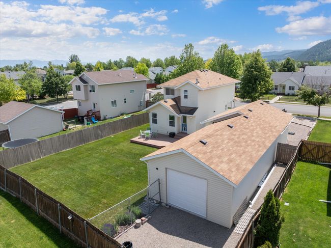 Aerial view of extended garage shop/storage, O/H door, and additional outdoor storage area | Image 39