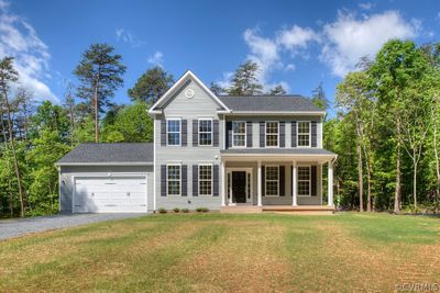 Colonial home featuring a garage, a porch, and a front yard | Image 2