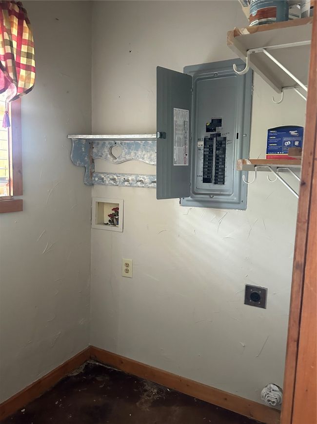 Washroom with electric panel, hookup for a washing machine, hookup for an electric dryer, and baseboards | Image 12