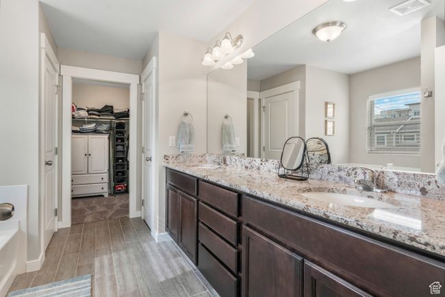 Bathroom featuring double vanity, visible vents, a spacious closet, and a sink | Image 15
