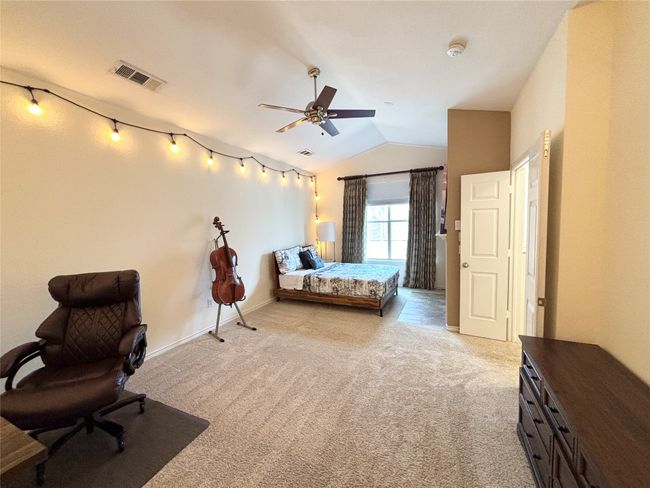 Bedroom featuring lofted ceiling, light colored carpet, baseboards, and ceiling fan | Image 13