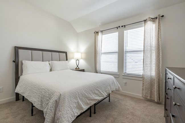 Bedroom with baseboards, light colored carpet, and vaulted ceiling | Image 18