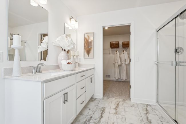 Photo is of the actual model. An extension of the primary bedroom, this private and spacious bath contains a double-vanity, a soaking tub, a shower, and a walk-in closet. | Image 21