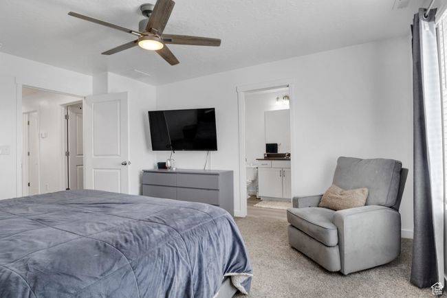 Carpeted bedroom with a ceiling fan, connected bathroom, and baseboards | Image 14