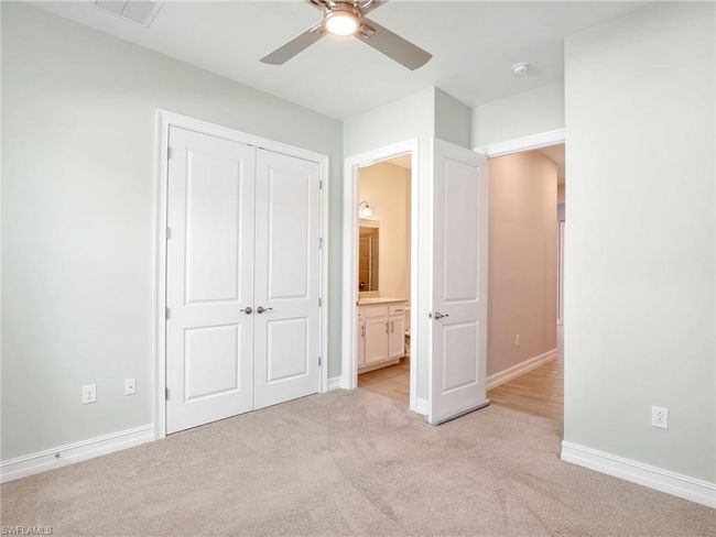 Unfurnished bedroom with light carpet, a closet, ensuite bath, and ceiling fan | Image 24