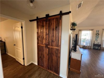 Hallway with a textured ceiling, vaulted ceiling, and dark hardwood / wood-style floors | Image 3