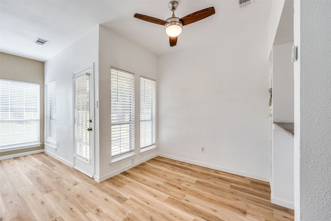 Dining area with windows, and granite counter pass-through to kitchen .Door on left walks out to the private patio. | Image 4