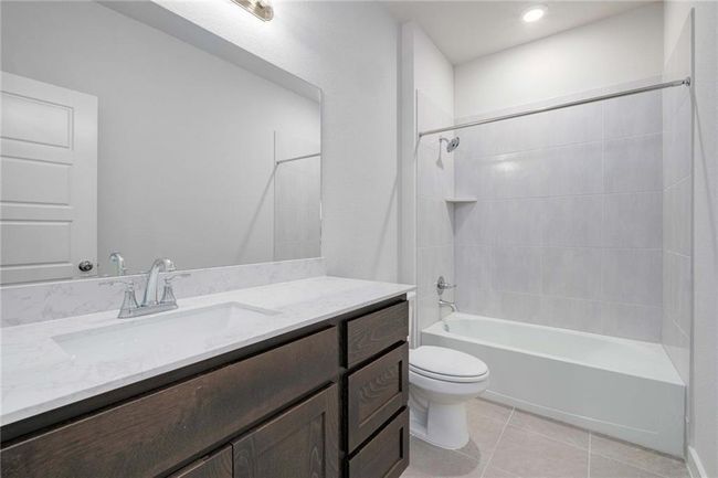 Full bathroom with large vanity, tile patterned flooring, and shower / bathtub combination | Image 18