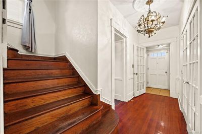 foyer, featuring entrance to office and French doors to living room, wide wood staircase to upper level | Image 2